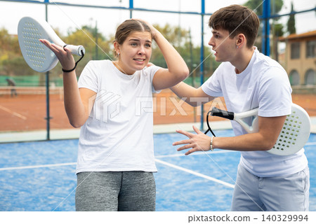 Guy comforting frustrated female paddle tennis partner Guy comforting frustrated female paddle tennis partner 140329994
