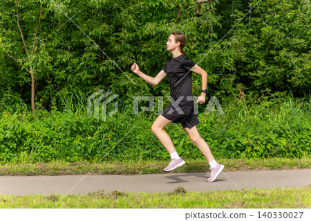 Young woman jogging on a park path Young woman jogging on a park path 140330027