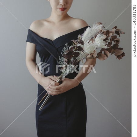 身穿婚紗的新娘手捧一束花。 身穿婚紗的新娘手捧一束花。 140331793