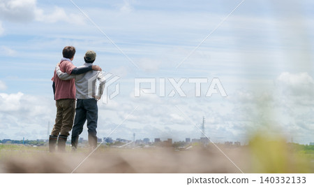 A banner showing the backs of two farm men with their arms around each other's shoulders. A banner showing the backs of two farm men with their arms around each other's shoulders. 140332133