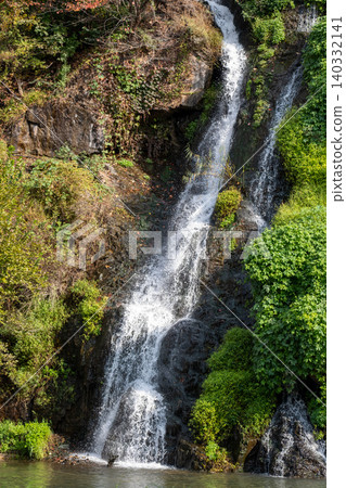 Close-up of waterfall with autumn foliage Close-up of waterfall with autumn foliage 140332141