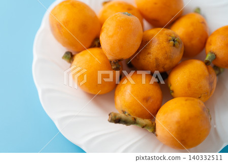 Irregularly shaped, organic, ripe loquats as background material | Natural imperfections and discoloration remain. Irregularly shaped, organic, ripe loquats as background material | Natural imperfections and discoloration remain. 140332511