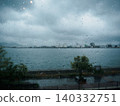The view through a windowpane covered in raindrops 140332751