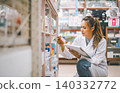 Pharmacist checking Checks Inventory of Medicine, Drugs, Vitamins with tablet and checking patient's prescription in modern pharmacy. 140332772