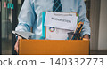 Young company employee packing office supplies and personal items in cardboard boxes before leaving the office to look for a new job, being fired, or being dismissed by the employer. 140332773