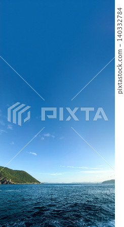A refreshing early summer coastal scene overlooking the blue sea and lush green cape. 140332784