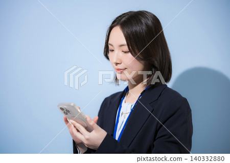 一位女商人正在使用智慧型手機搜尋、尋找、查詢和查看聯絡人,所有操作均在淺藍色背景下進行。 一位女商人正在使用智慧型手機搜尋、尋找、查詢和查看聯絡人,所有操作均在淺藍色背景下進行。 140332880