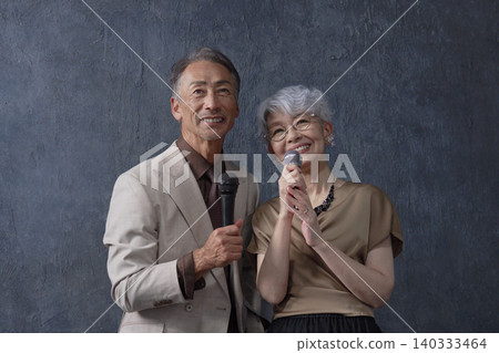Senior men and women singing karaoke on a black background Senior men and women singing karaoke on a black background 140333464