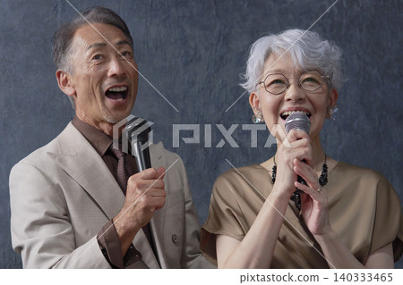 Senior men and women singing karaoke on a black background Senior men and women singing karaoke on a black background 140333465