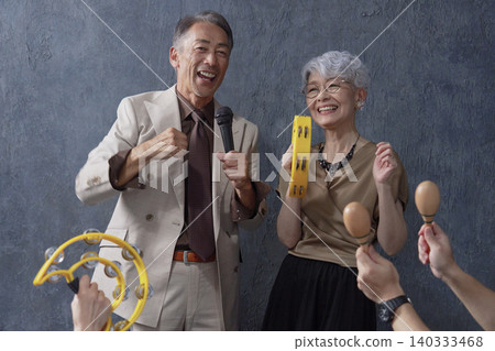 Senior men and women singing karaoke on a black background Senior men and women singing karaoke on a black background 140333468