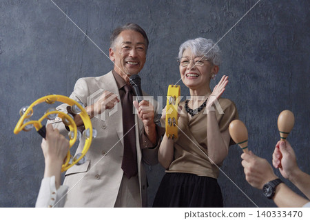 Senior men and women singing karaoke on a black background Senior men and women singing karaoke on a black background 140333470