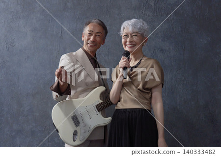 Senior musicians: male guitarist and female vocalist, black background Senior musicians: male guitarist and female vocalist, black background 140333482