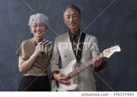 資深音樂家，男吉他手和女歌手，黑色背景，看向鏡頭 140333484