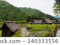 A village of thatched-roof houses nestled in the mountains 140333556