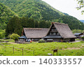 A village of thatched-roof houses nestled in the mountains 140333557
