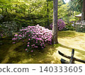 A moss-covered Japanese garden adorned with fresh greenery and flowers. 140333605