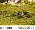 A stone Jizo statue covered in moss 140333611