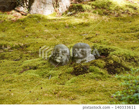 A stone Jizo statue covered in moss A stone Jizo statue covered in moss 140333611