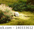 A stone Jizo statue covered in moss 140333612