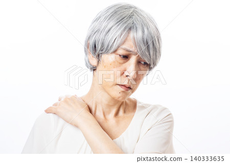 A senior woman with gray hair suffering from severe shoulder stiffness. A senior woman with gray hair suffering from severe shoulder stiffness. 140333635