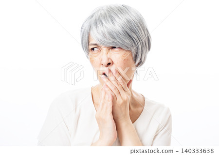 A senior woman with white hair who speaks ill of others 140333638