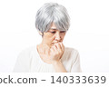 一位白髮蒼蒼的老婦人，身穿白色襯衫，低著頭。 140333639