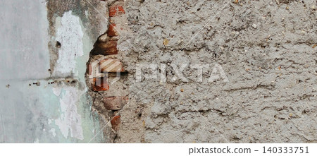 Damaged plaster walls with visible brick texture and weathered concrete surfaces 140333751