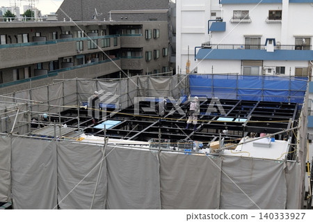 steel frame construction, Construction Workers Installing Steel Frame Structure at Urban Building Site steel frame construction, Construction Workers Installing Steel Frame Structure at Urban Building Site 140333927