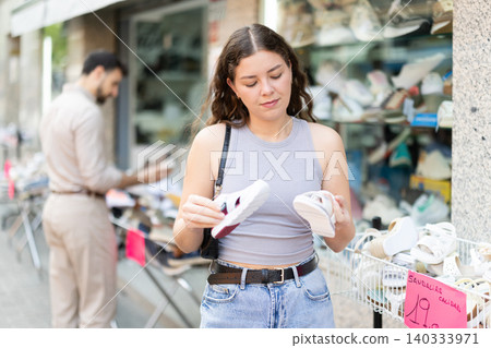 Woman buys childrens shoes at discounts Woman buys childrens shoes at discounts 140333971