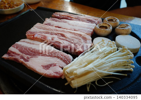Traditional Korean barbecue K-BBQ fresh pork belly slices with enoki mushrooms 140334095