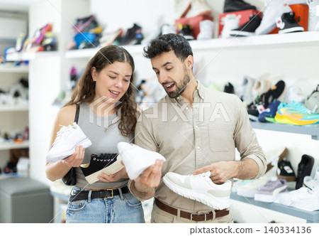 Man helps girl choose sneakers 140334136
