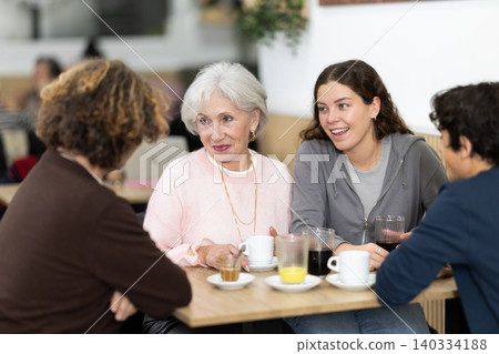 Large friendly family gathered at table to have meeting in restaurant Large friendly family gathered at table to have meeting in restaurant 140334188