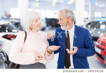 Senior woman is happy with a set of keys and the purchase of a new car Senior woman is happy with a set of keys and the purchase of a new car 140334226