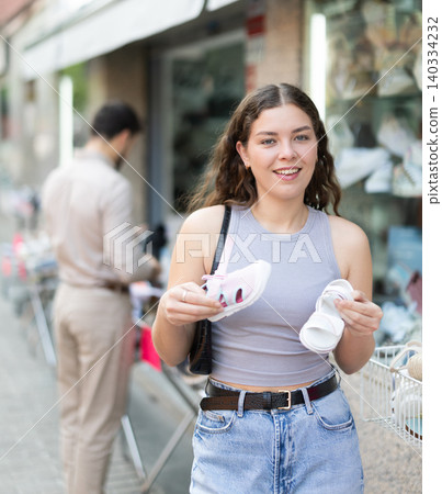 Woman buys childrens shoes at discounts Woman buys childrens shoes at discounts 140334232
