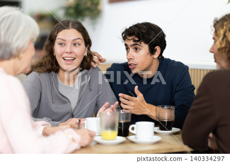 Large friendly family gathered at table to have meeting in restaurant Large friendly family gathered at table to have meeting in restaurant 140334297
