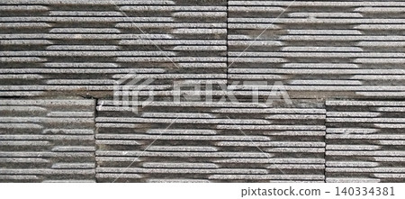 The texture of the gray stone wall is arranged without joints with a horizontal layer pattern. The texture of the gray stone wall is arranged without joints with a horizontal layer pattern. 140334381