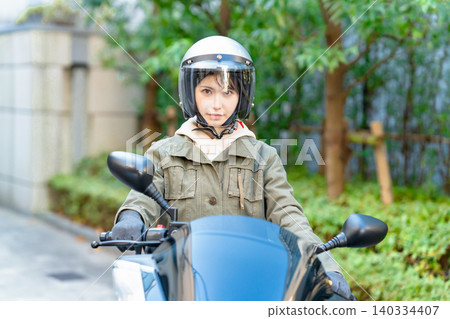 A woman riding a scooter A woman riding a scooter 140334407
