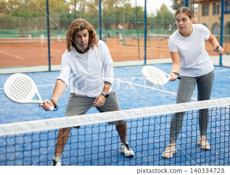 Portrait of female trainer teaching man playing padel Portrait of female trainer teaching man playing padel 140334728