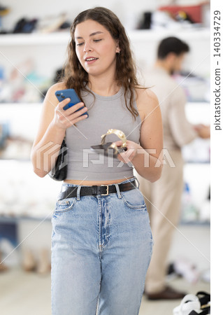 Young woman scanning barcode on sandal label in store Young woman scanning barcode on sandal label in store 140334729
