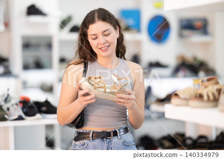 Woman choosing sandals in shoe store 140334979