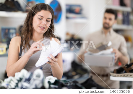 Young woman choosing sneakers at shoe store Young woman choosing sneakers at shoe store 140335096