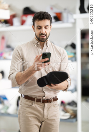 Adult man scanning QR code on classic dress shoes at shoe store Adult man scanning QR code on classic dress shoes at shoe store 140335216
