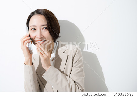 特寫鏡頭:身著職業套裝的女商人們正偷偷地用智慧型手機聊天,分享評論和口碑訊息。 特寫鏡頭:身著職業套裝的女商人們正偷偷地用智慧型手機聊天,分享評論和口碑訊息。 140335583