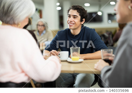 Happy young guy meeting and celebration with big friendly family over dinner in restaurant 140335696