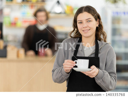 Female cafe employee carries coffee in cozy cafe Female cafe employee carries coffee in cozy cafe 140335768