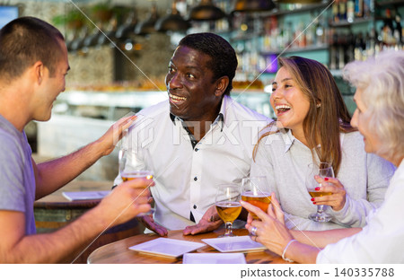 People talking and toasting in pub with the beers 140335788