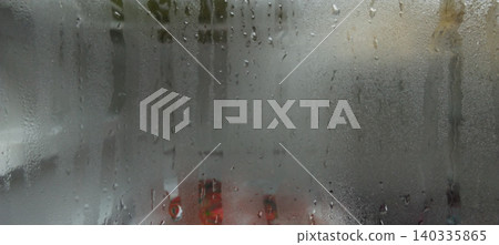 The window was wet from the rain with water droplets and a background texture of condensation. 140335865