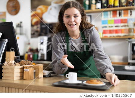 Cafe waitress carries tray with croissant and coffee 140335867