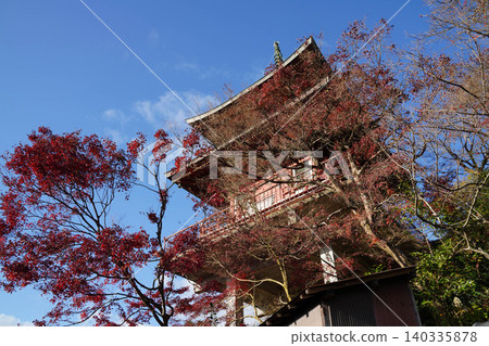 A multi-storied pagoda of a Buddhist temple in Kamitakano, northern Kyoto, against a backdrop of a blue sky. A multi-storied pagoda of a Buddhist temple in Kamitakano, northern Kyoto, against a backdrop of a blue sky. 140335878
