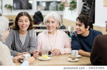 older generation of the family communicates with their grandchildren in a cafe older generation of the family communicates with their grandchildren in a cafe 140335905